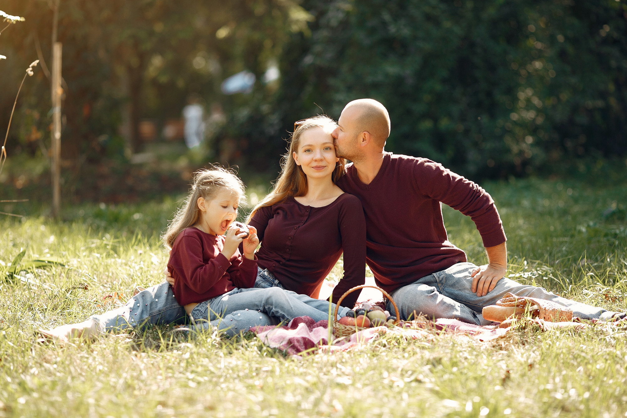 Young family sitting on a picnic blanket in the sun, symbolizing the peace of mind that term life vs whole life insurance can help provide