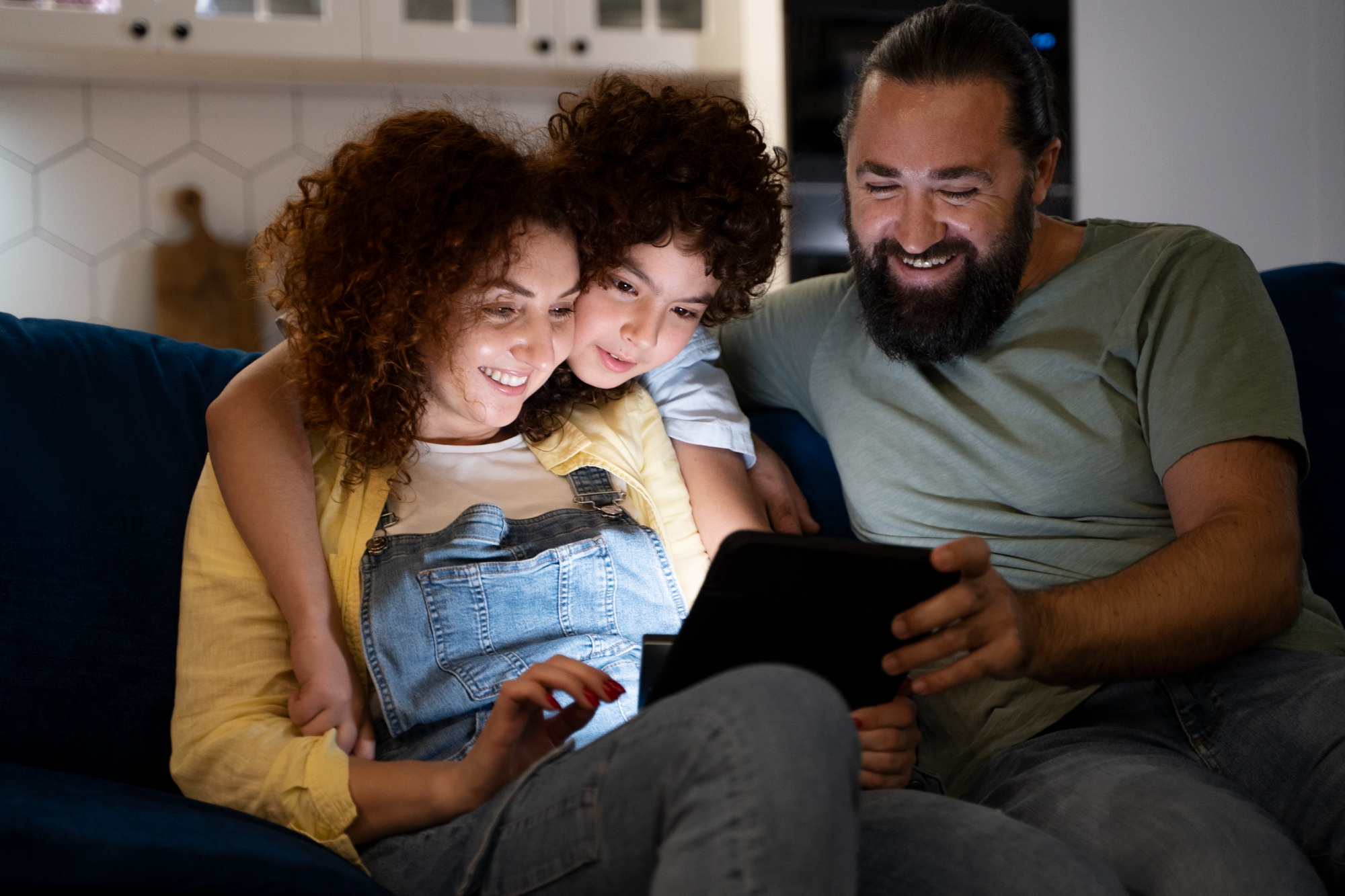 Smiling family enjoying content on tablet at home in the evening
